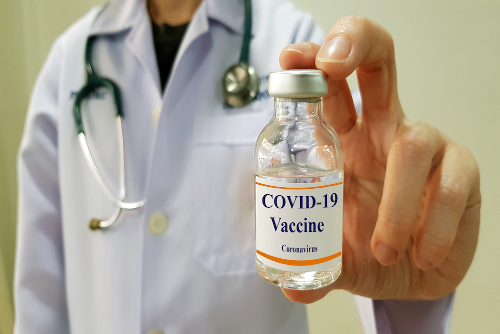 Simulated photo of doctor showing covid-19 vaccine