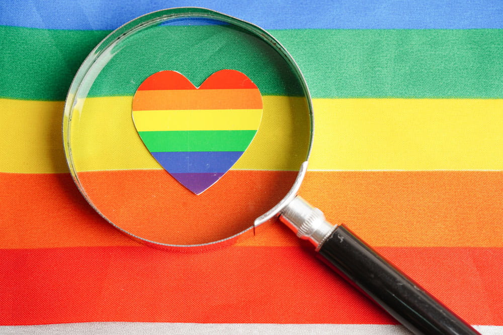 Magnifying glass with heart on rainbow flag, symbol of LGBT pride month celebrate annual in June social, symbol of gay, lesbian, bisexual, transgender, human rights and peace.