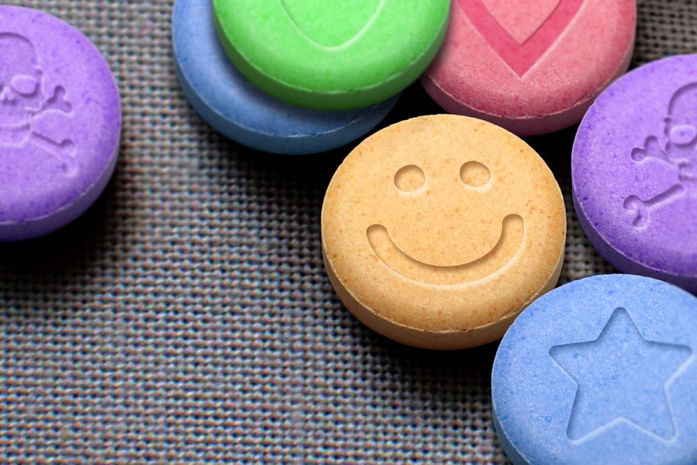 MDMA or Ecstasy pills on fabric background.